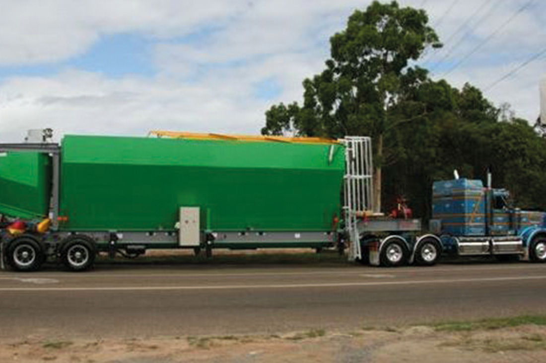 Side view of a green mobile silo on the road | featured image for Mobile Silo & Loss of Weight / Cement Weigh Hopper.