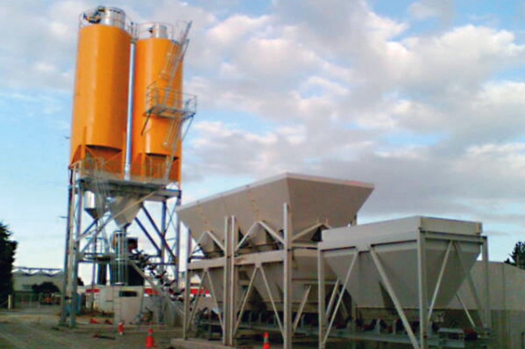 Orange silos connected to a concrete batching plant | Featured image for the Concrete Batching Plants products from CMQ Engineering.