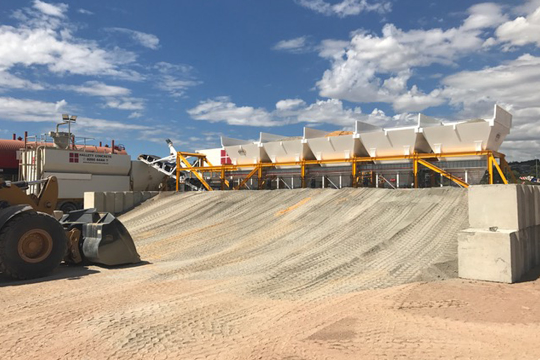 Photo a bank of sand in front of processing equipment | Featured image for the Aggregate Weigh Trailer Page for CMQ Engineering.