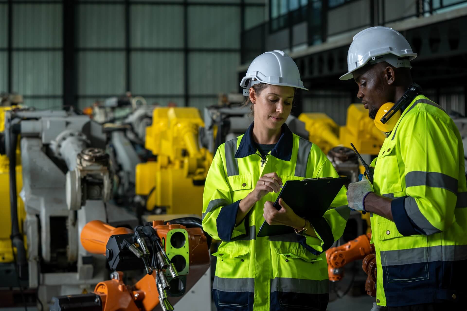 Workers examining a clipboard in front of many mining robots | Featured image for the Innovation in Mining blog from CMQ Engineering Australia.