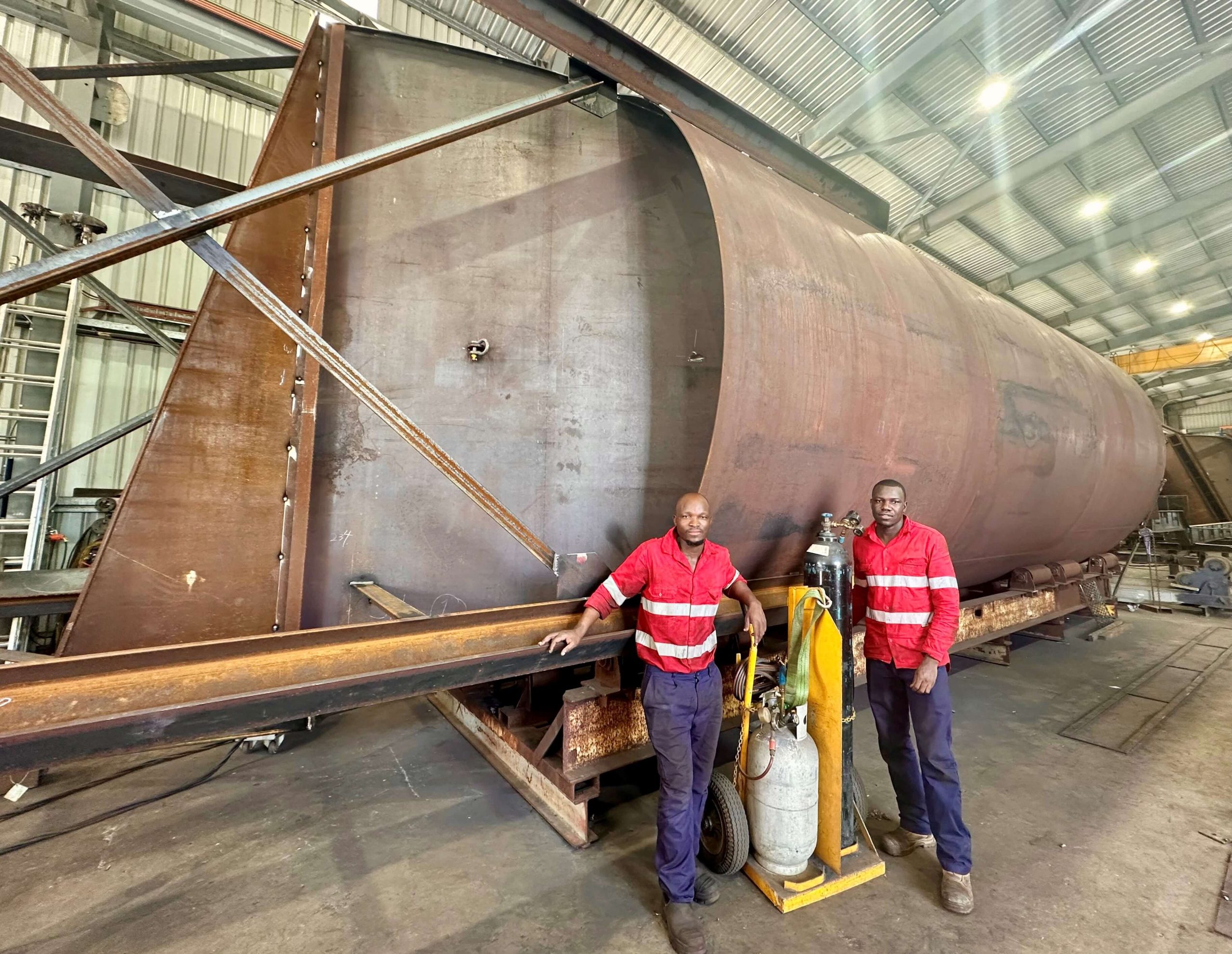 CMQ Engineering employees posing for a picture next to a boiler